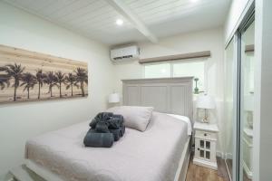 怀卢库401 Maalaea Banyans的一间设有白色床和棕榈树的卧室