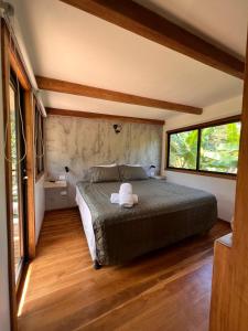 CabuyaFeeling Trees Jungle Lodge的一间卧室设有一张床和两个窗户。