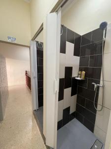 圣朱利安斯Ommi Hostel的浴室铺有黑白瓷砖,设有淋浴。