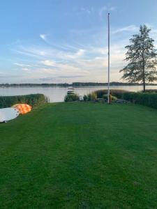 SundsHuset ved søen tæt på Herning og MCH og boxen 90 m2的水体旁的草场