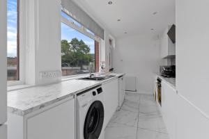 SkegbyModern 3-Bed Terraced House in Sutton-In-Ashfield的白色的厨房配有洗衣机和窗户。