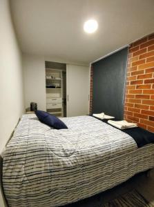危地马拉Luxury Apartment, 1110 Z.4的一间卧室设有一张带砖墙的大床