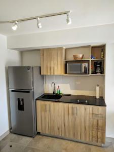 危地马拉Luxury Apartment, 1110 Z.4的厨房配有不锈钢冰箱和木制橱柜