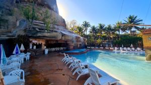 卡达斯诺瓦斯Hotel Spazzio diRoma GRATIS entrada Acqua e Splash Caldas novas的度假村的游泳池,设有白色椅子和游泳池