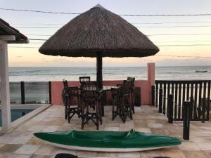 佩巴州蓬塔尔B&B Beach House Pousada Exclusiva pés na água Pontal do Peba única em Alagoas的桌椅、雨伞和绿船