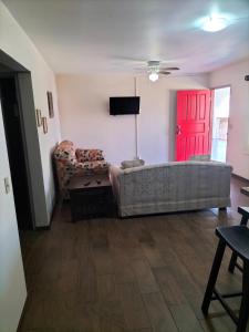 恩塞纳达港Adanesne Apartments的带沙发和红色门的客厅