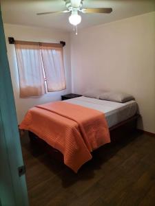 恩塞纳达港Adanesne Apartments的一间卧室配有一张带橙色毯子的床
