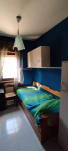 桑格罗堡Casa vancanze con camino的一间卧室配有一张蓝色墙壁的床