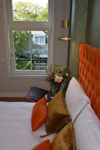 阿姆斯特丹The IF Boutique hotel的一间卧室配有一张带橙色床头板和窗户的床。