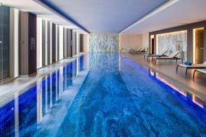 利雅德Hilton Garden Inn Riyadh Financial District的蓝色海水游泳池,位于酒店客房内