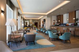 利雅德Hilton Garden Inn Riyadh Financial District的酒店大堂设有桌椅和酒吧