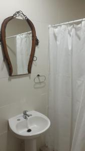特雷利乌Cabaña La Escondida的白色的浴室设有水槽和镜子