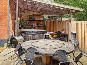 格林斯泰兹Holiday home Grindsted IV的庭院配有木桌、椅子和烧烤架。