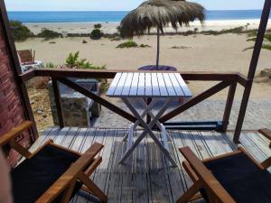巴伊亚英格莱萨帕拉伊索度假屋的海滩上带桌椅的木制甲板