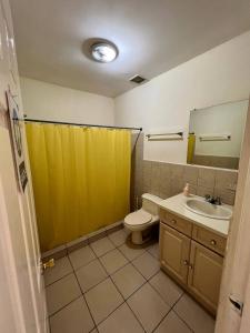 马那瓜SAM TRAVEL的浴室设有黄色的淋浴帘和卫生间