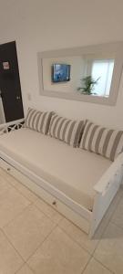 GualeguaychúALOJAMIENTO LA ESTACIÓN的客房内的白色沙发,带条纹枕头