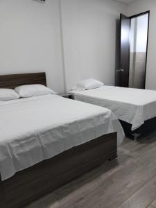 阿卡西亚斯Hotel Guadalupe Acacías的卧室内两张并排的床