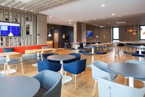 雷姆沙伊德Holiday Inn Express - Remscheid的一间带桌椅和电视的餐厅