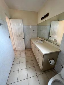 马那瓜SAM TRAVEL的一间带水槽、镜子和卫生间的浴室