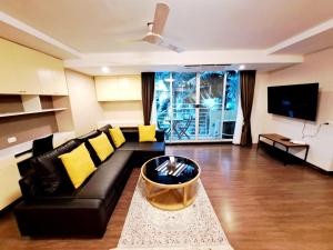 Bang KapiBangkok Downtown 2bedrooms3bth Near Asoke Btsmrt No1的客厅配有黑色沙发和黄色枕头
