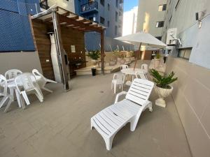 马塞约Confortável quarto e sala com Manobrista, Wi-fi, Tv Smart - Apto 208的庭院里摆放着一组白色的桌椅