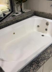 布拉干萨-保利斯塔Tennessee Motel ltda的浴室设有白色浴缸及镜子
