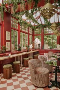 伦敦Ember Locke Kensington的餐厅拥有红色的墙壁和椅子,设有窗户