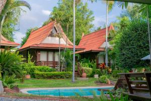华欣班東考度假村 的一座带橙色屋顶和游泳池的房子