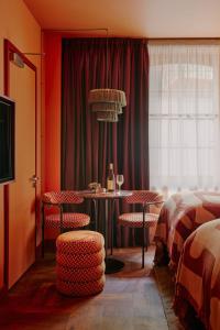 伦敦Ember Locke Kensington的酒店客房配有桌椅和一张床