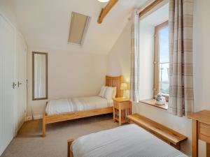 LlancarvanThe Gallops的一间卧室设有两张床和窗户。