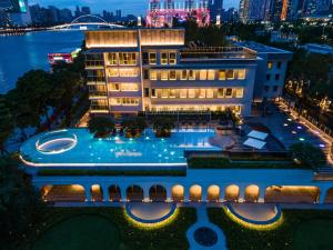 广州Hotel Indigo Guangzhou Haixinsha, an IHG Hotel - Complimentary Social hour at Flow and Free Shuttle Bus in Canton Fair Period的享有酒店空中景色,晚上设有游泳池