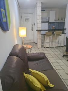 圣路易斯Flat Number One - Fonseca Imóveis的一间带棕色沙发的客厅和一间厨房