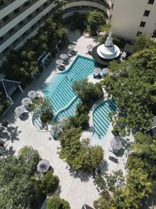 芭东海滩The Royal Paradise Hotel & Spa - SHA Extra Plus的享有带椅子和遮阳伞的游泳池的上方景致