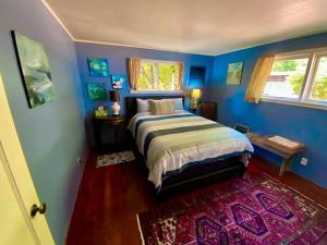 Ocean ParkOcean Park Beach Cottage的一间卧室配有一张蓝色墙壁和地毯的床