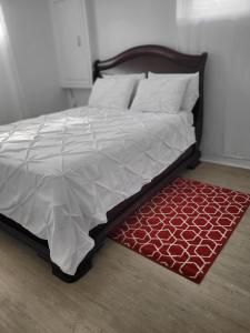 加蒂诺Sheena palace的一张带白色棉被和红色地毯的床