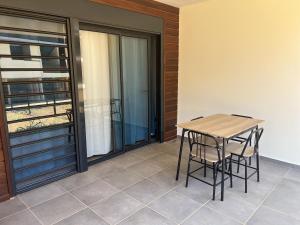 RémiréAPPARTEMENT T3 COSY et PAISIBLE avec JARDIN à REMIRE-MONTJOLY的露台的阳台配有桌椅