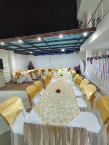 通苏帕Hostería Luz Del Mar的一个带白色桌子和黄色椅子的大型宴会厅