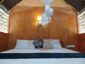 锡吉里亚Pidurangala View Treehouse的一张带白色枕头和灯具的床