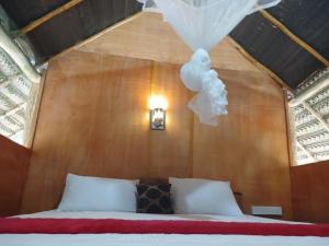 锡吉里亚Pidurangala View Treehouse的卧室配有木墙内的一张床