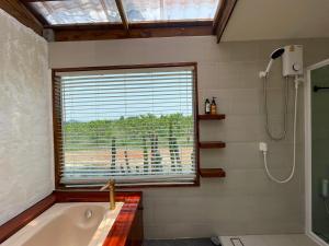 Ban Nong Khwangกระบองแพะ的带浴缸、窗户和淋浴的浴室