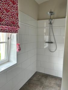 BlumenowStorchenhof Blumenow的白色瓷砖淋浴和红色淋浴帘