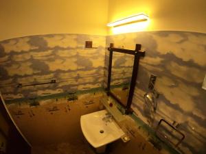 贝里胡罗亚Mount Seven Holiday Inn的浴室设有水槽,墙上涂有云彩