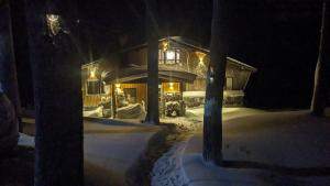 饭山市Japan Snowsports的雪中的房子,晚上有灯