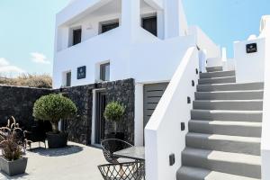 莫诺利索斯Villa Eleana的白色的房子,设有楼梯和桌子