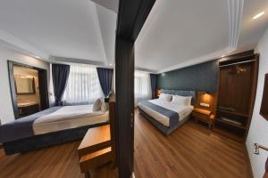 安卡拉BUKAVİYYE HOTEL的酒店客房设有两张床和窗户。