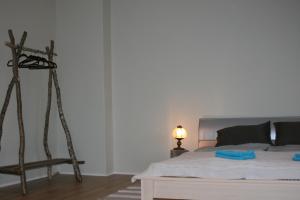 普里恩斯慕斯Brīvdienu māja Tobago的一间卧室配有一张床铺,旁边设有一张三脚架