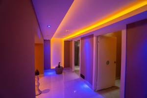 马赫姆拉Senza Grand Santana Hotel - Ultra All Inclusive的天花板上设有紫色和蓝色灯的走廊