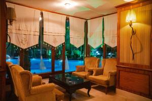 马赫姆拉Senza Grand Santana Hotel - Ultra All Inclusive的客厅配有椅子、桌子和窗户