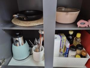 大邱DAON STAR BnB j6的一个带餐具的厨房架和其他厨房用品