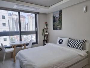 大邱DAON STAR BnB j6的一间卧室配有一张床、一张桌子和一个窗户。